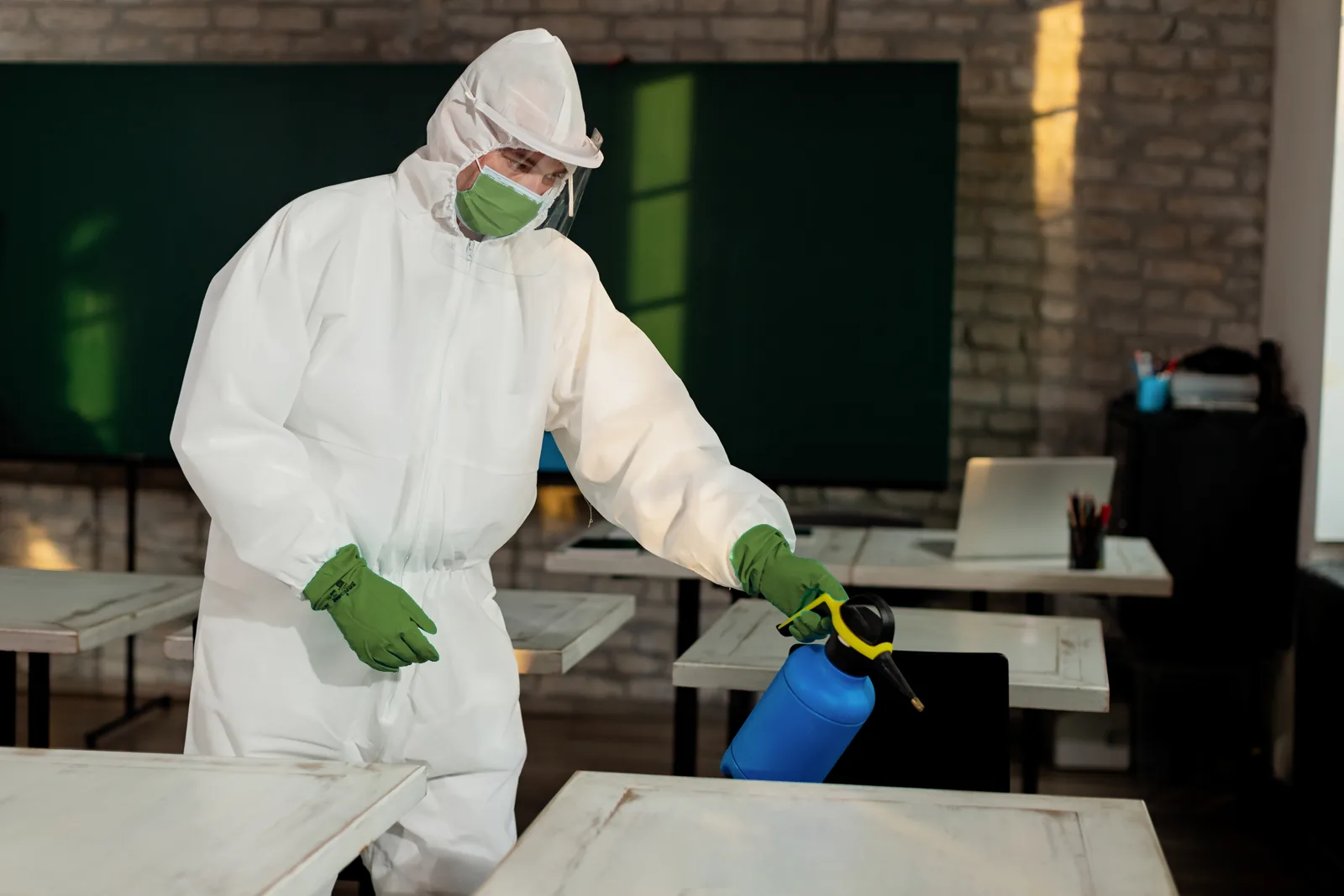 Uncled Ants technician in protective gear treating a room